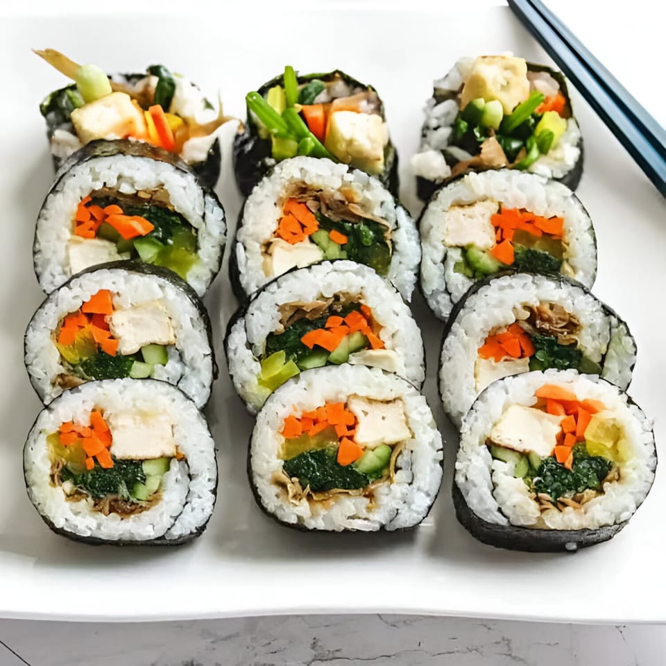 Platter of HanKki's Korean gimbap rolls filled with rice, vegetables, and tofu, with chopsticks.